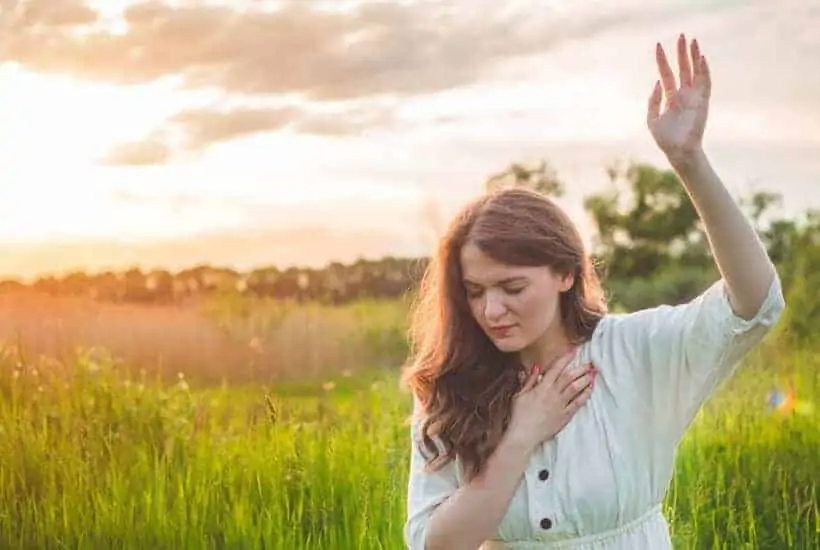 Prayer Changes Things 6 Powerful Stories You Need To Know 2 a woman on her knees in a field hand raised high praying How the Power of Prayer Changes Things