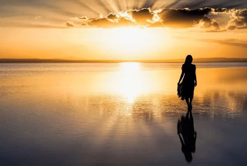 Do You Know The Importance Of Walking With God? 1 an image of a woman walking the beach with a golden sunset in the background featured image for Do You Know The Importance Of Walking With God?