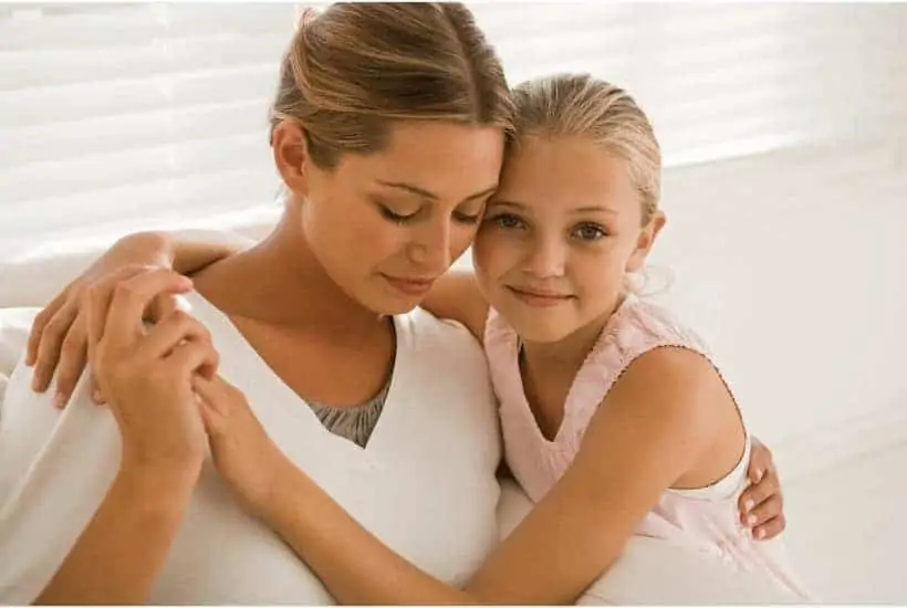 When Mother's Day is Hard: A Mother's Day Prayer for You 1 an image of a mother and small child sitting on a couch with their arms around one another with featured image for When Mother's Day is Hard